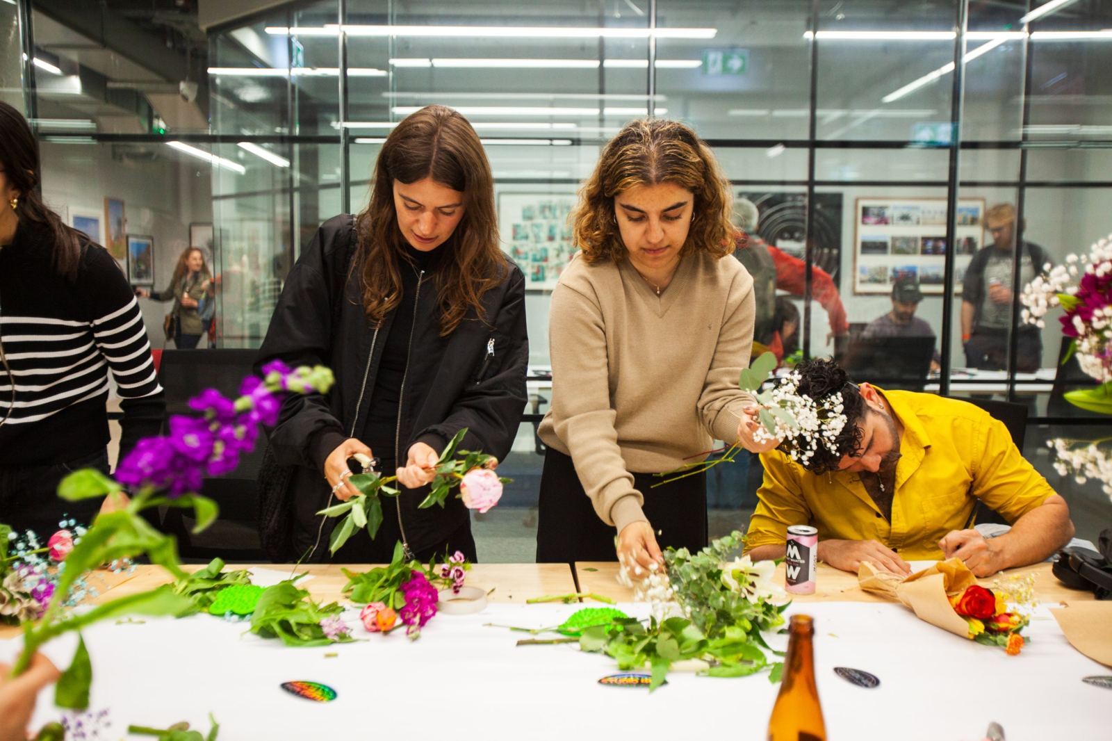 Guests choosing stems and wrapping bouquets around a shared table