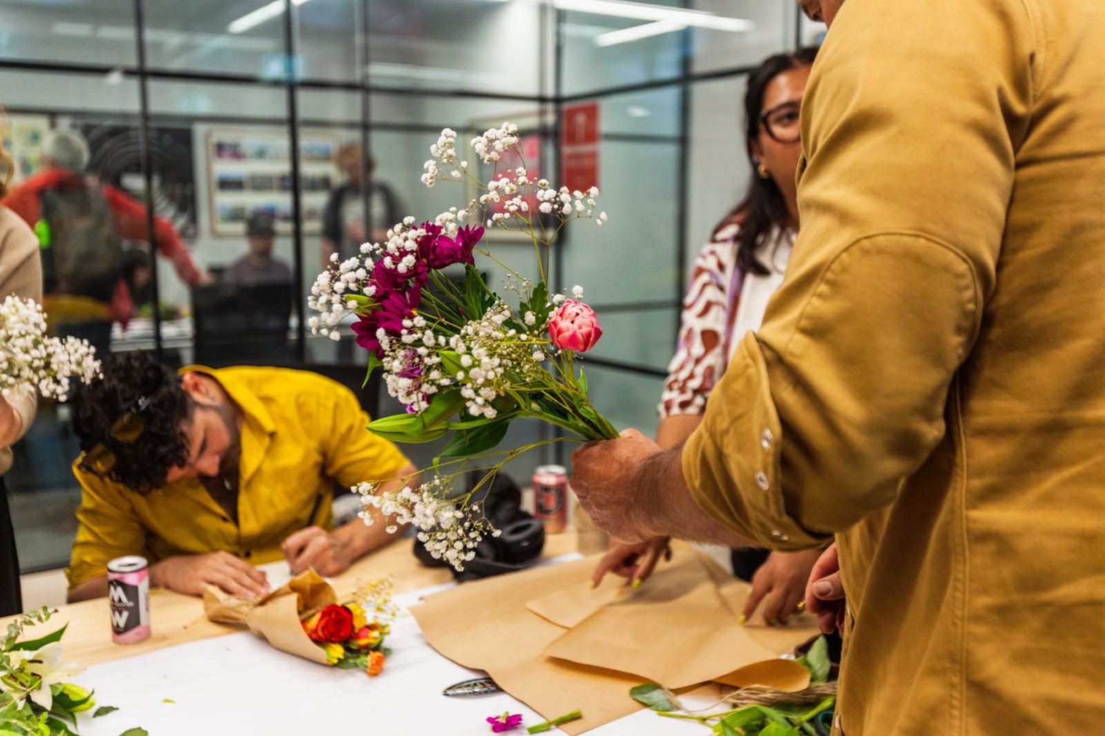 Wrapping a finished bouquet in kraft paper at a workshop